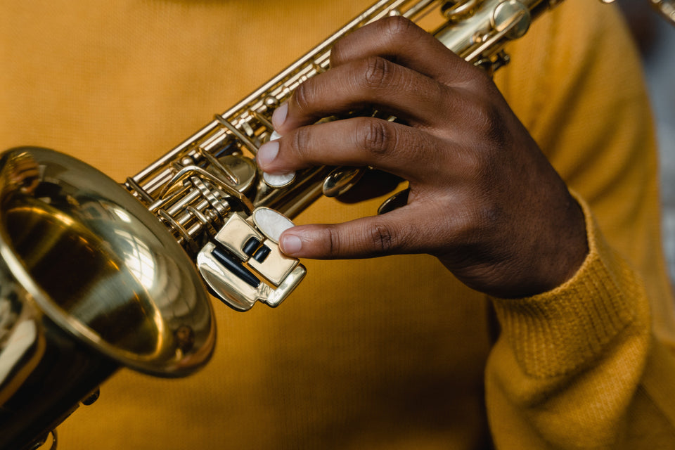 Die Linke Hand eines Saxophonschülers in der Ruheposition auf den Tasten eines Saxophon