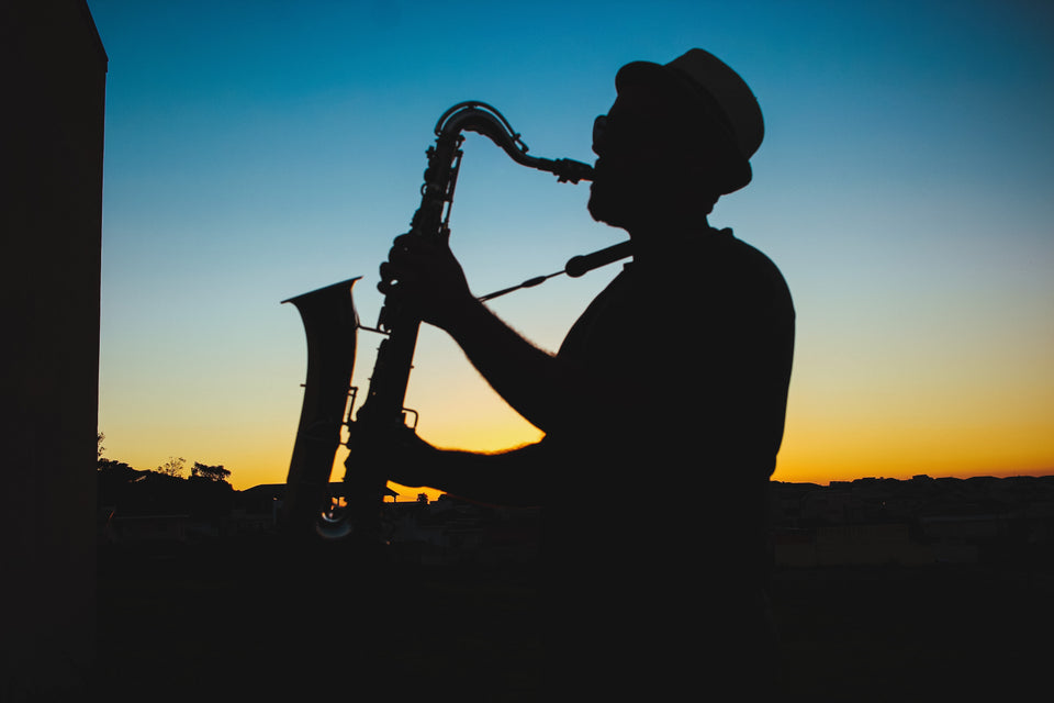 Ein Saxophonist spielt im Sonnenuntergang Tenorsaxophon